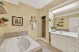 Indulge in relaxation in this luxurious bathroom featuring a spacious corner jacuzzi tub perfect for unwinding.