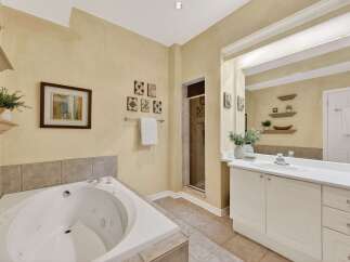 Indulge in relaxation in this luxurious bathroom featuring a spacious corner jacuzzi tub perfect for unwinding.