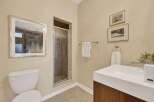This bathroom features a modern white vanity with a sleek faucet and a built-in sink, complemented by a stylish soap dispenser and a decorative plant.