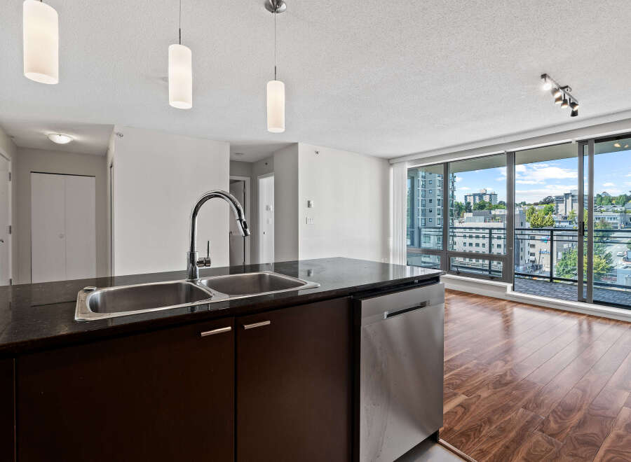 Experience modern living in this stunning condo featuring a sleek kitchen island with a double sink and stainless steel dishwasher.