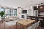 Experience modern living in this stunning condo featuring a spacious open-concept living area with a cozy fireplace and large windows.