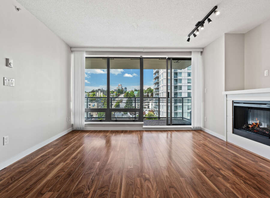 Experience modern living in this spacious apartment featuring a cozy fireplace and expansive windows that flood the space with natural light.