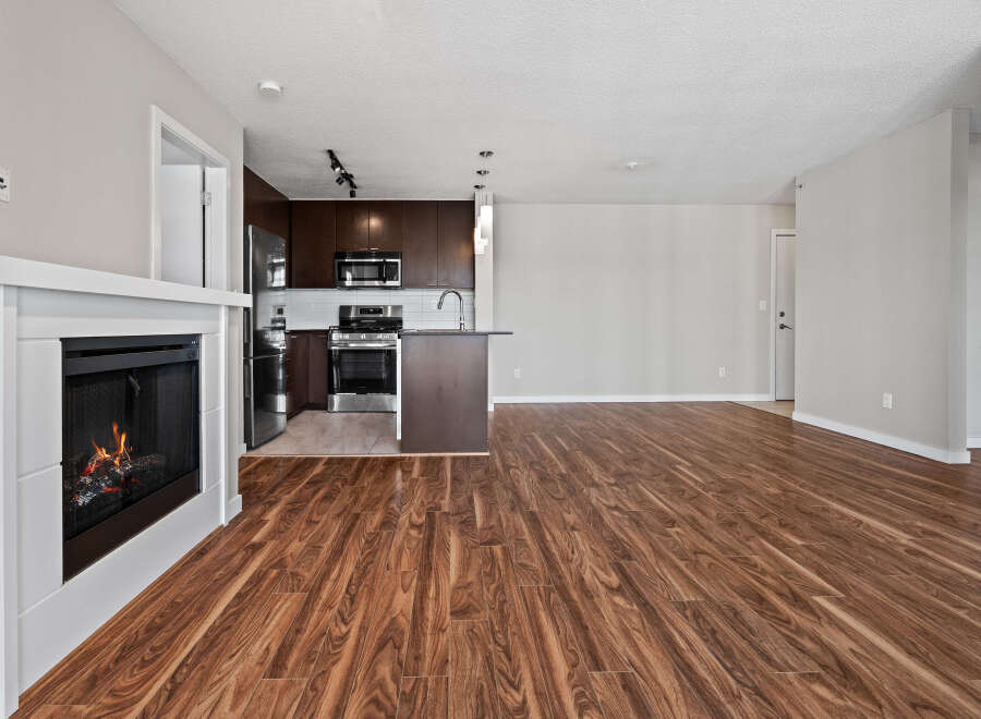 Experience modern living in this spacious open-concept home featuring a cozy fireplace and a sleek, contemporary kitchen.