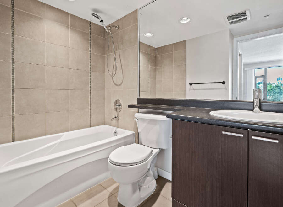 This modern bathroom features a deep soaking tub and a sleek vanity with ample storage.