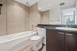 This modern bathroom features a deep soaking tub and a sleek vanity with ample storage.