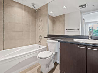 This modern bathroom features a deep soaking tub and a sleek vanity with ample storage.