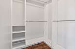 This spacious walk-in closet features a clean, modern design with ample shelving and multiple hanging rods.