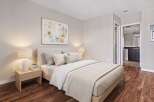 Experience comfort and style in this beautifully appointed bedroom, featuring a plush bed, elegant nightstands with lamps, and a captivating piece of wall art.