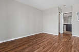 Experience modern living in this spacious room featuring elegant hardwood-style flooring and neutral gray walls.