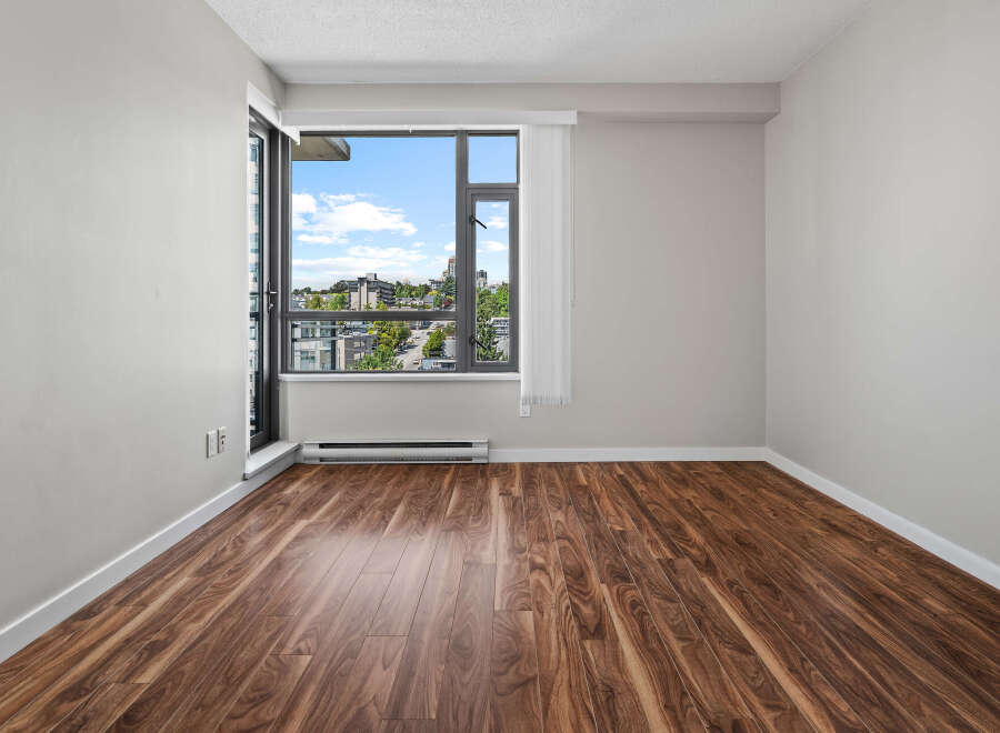Experience modern living in this bright and airy room featuring a large window with stunning city views.