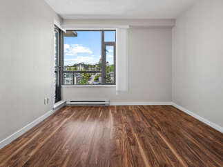 Experience modern living in this bright and airy room featuring a large window with stunning city views.