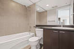 This modern bathroom features a deep soaking tub and a sleek vanity with ample storage.