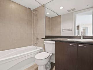 This modern bathroom features a deep soaking tub and a sleek vanity with ample storage.