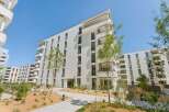 Discover modern living in this stunning white apartment building, featuring a contemporary design with clean lines and ample balconies.