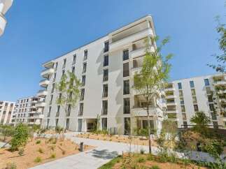Discover modern living in this stunning white apartment building, featuring a contemporary design with clean lines and ample balconies.