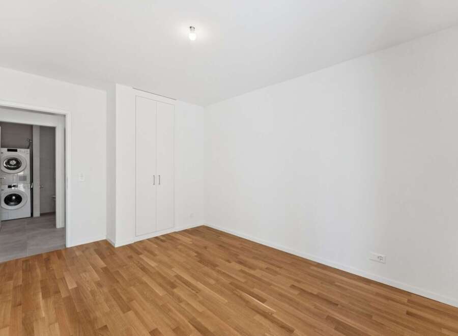 Discover this beautifully appointed room featuring gleaming hardwood floors and ample storage space with a built-in wardrobe.