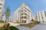 Discover modern living in this stunning apartment complex featuring sleek white facades and expansive balconies perfect for enjoying the outdoors.