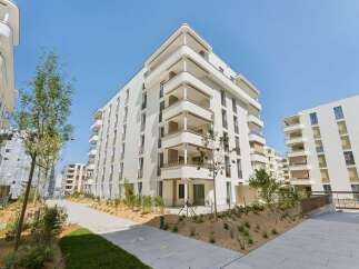 Discover modern living in this stunning apartment complex featuring sleek white facades and expansive balconies perfect for enjoying the outdoors.