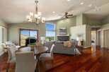 Experience breathtaking views from this stunning living and dining area, featuring a vaulted ceiling with a modern chandelier and a cozy fireplace.
