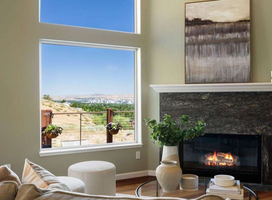 Experience breathtaking panoramic views from this stunning living room, featuring a large picture window that frames a picturesque landscape.