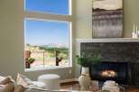 Experience breathtaking panoramic views from this stunning living room, featuring a large picture window that frames a picturesque landscape.