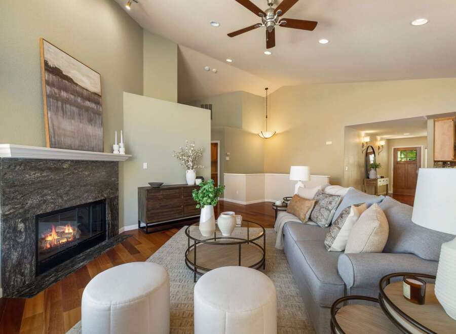 Experience elegant living in this spacious great room, featuring a stunning stone fireplace and vaulted ceilings with a ceiling fan.