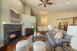 Experience elegant living in this spacious great room, featuring a stunning stone fireplace and vaulted ceilings with a ceiling fan.