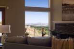 Experience breathtaking panoramic views from this stunning home, featuring expansive windows that showcase a vibrant cityscape and rolling hills.