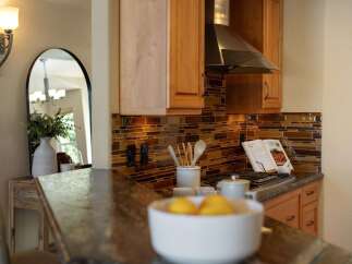 This kitchen features a beautiful mosaic tile backsplash that adds warmth and texture to the space.