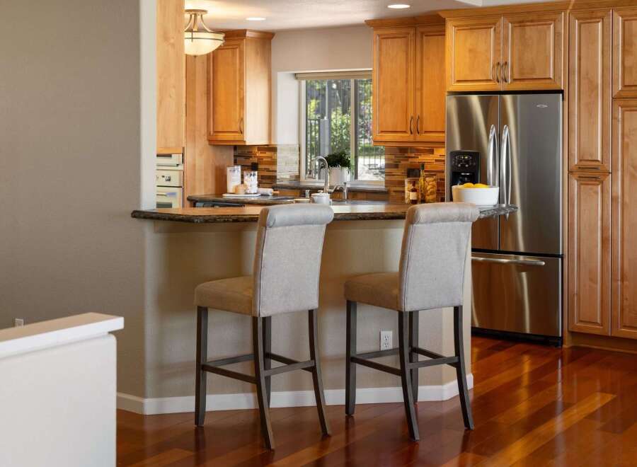 This inviting kitchen features warm wood cabinetry and a spacious granite countertop island, perfect for casual dining or entertaining.