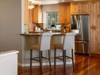 This inviting kitchen features warm wood cabinetry and a spacious granite countertop island, perfect for casual dining or entertaining.