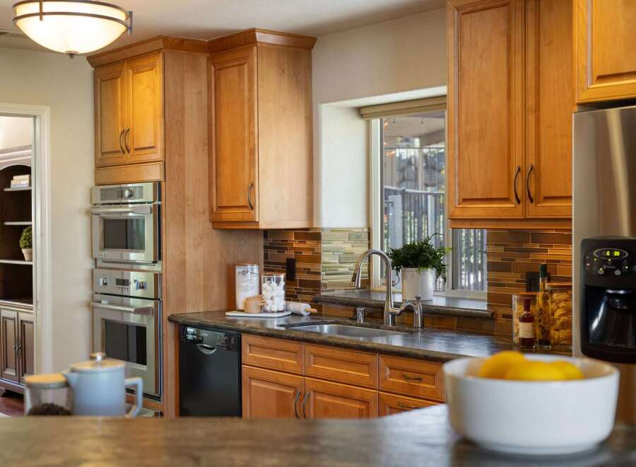 This stunning kitchen boasts a sleek stainless steel double oven and a built-in dishwasher, perfect for any home chef.