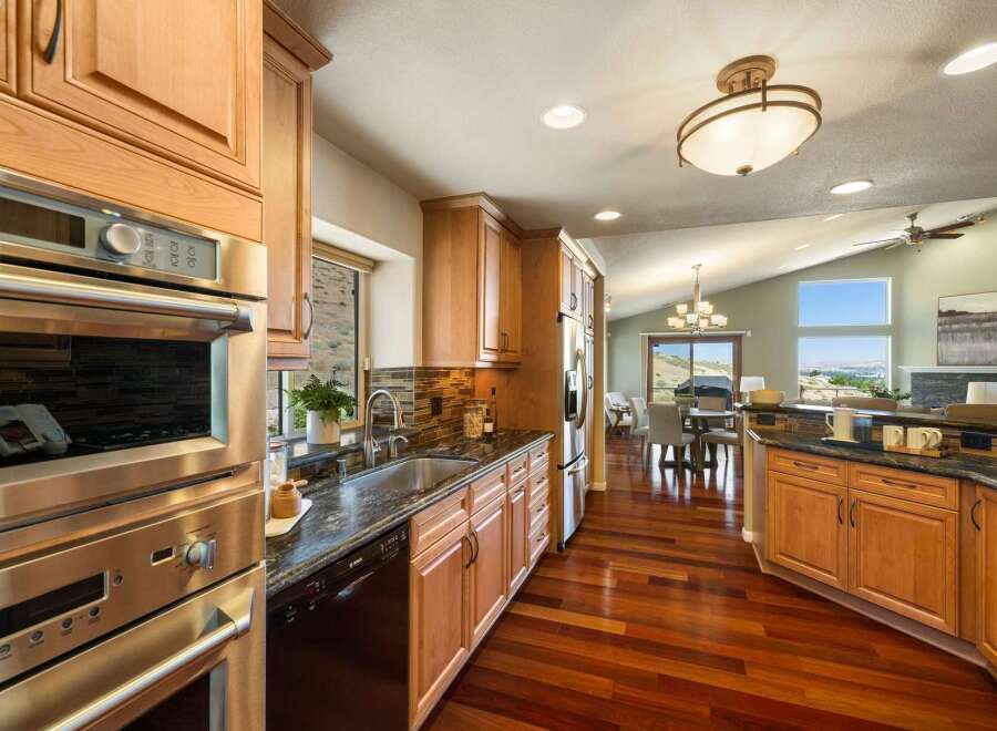 Experience luxury living in this stunning kitchen featuring sleek stainless steel appliances, granite countertops, and rich hardwood flooring.