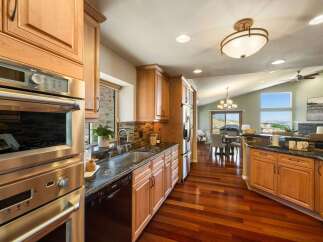 Experience luxury living in this stunning kitchen featuring sleek stainless steel appliances, granite countertops, and rich hardwood flooring.
