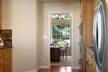 Step into a charming home office space, bathed in natural light from a large window overlooking lush greenery.