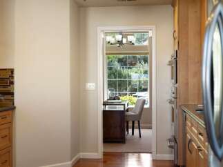 Step into a charming home office space, bathed in natural light from a large window overlooking lush greenery.