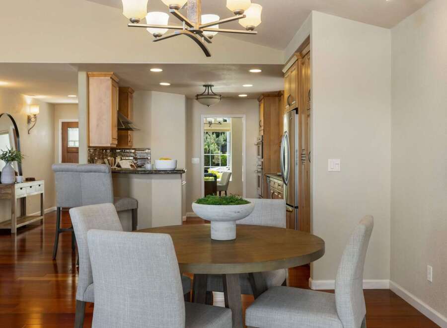 This inviting dining area features a round wooden table with upholstered chairs, perfect for intimate gatherings.