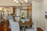 This inviting dining area features a round wooden table with upholstered chairs, perfect for intimate gatherings.