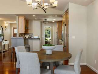 This inviting dining area features a round wooden table with upholstered chairs, perfect for intimate gatherings.