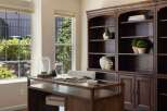 This home office features a spacious wooden desk with a glass top, perfect for productivity.