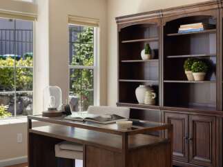 This home office features a spacious wooden desk with a glass top, perfect for productivity.