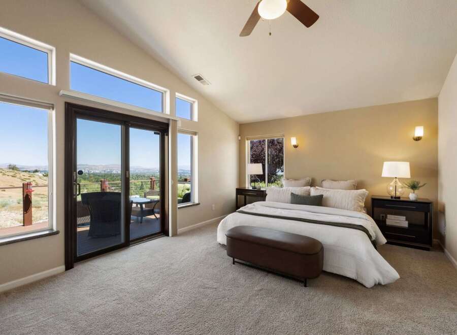 Experience breathtaking panoramic views from this stunning master bedroom, featuring expansive windows and a private balcony perfect for enjoying the scenery.