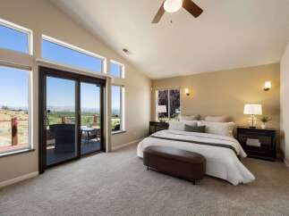 Experience breathtaking panoramic views from this stunning master bedroom, featuring expansive windows and a private balcony perfect for enjoying the scenery.