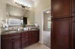 This spacious bathroom features a double vanity with granite countertops and dark wood cabinetry, offering ample storage.