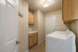 This laundry room offers ample storage with both upper and lower cabinets, perfect for organizing supplies.