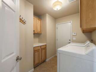 This laundry room offers ample storage with both upper and lower cabinets, perfect for organizing supplies.