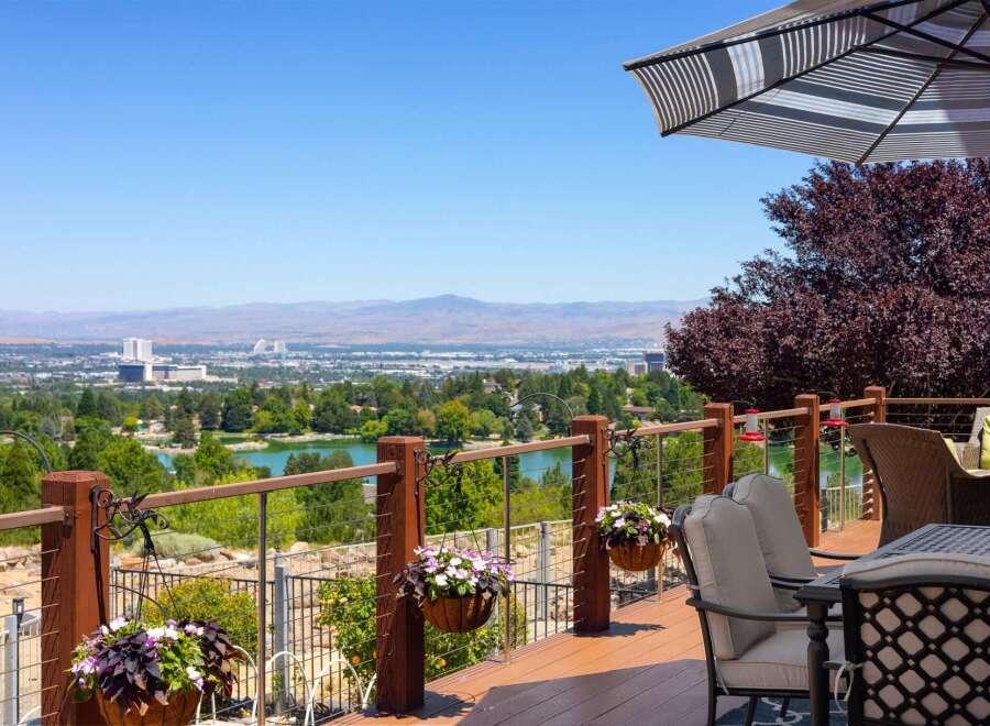 Enjoy breathtaking panoramic views from this stunning deck, overlooking a serene lake and a distant cityscape.