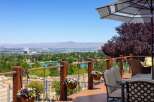 Enjoy breathtaking panoramic views from this stunning deck, overlooking a serene lake and a distant cityscape.