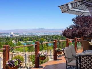 Enjoy breathtaking panoramic views from this stunning deck, overlooking a serene lake and a distant cityscape.