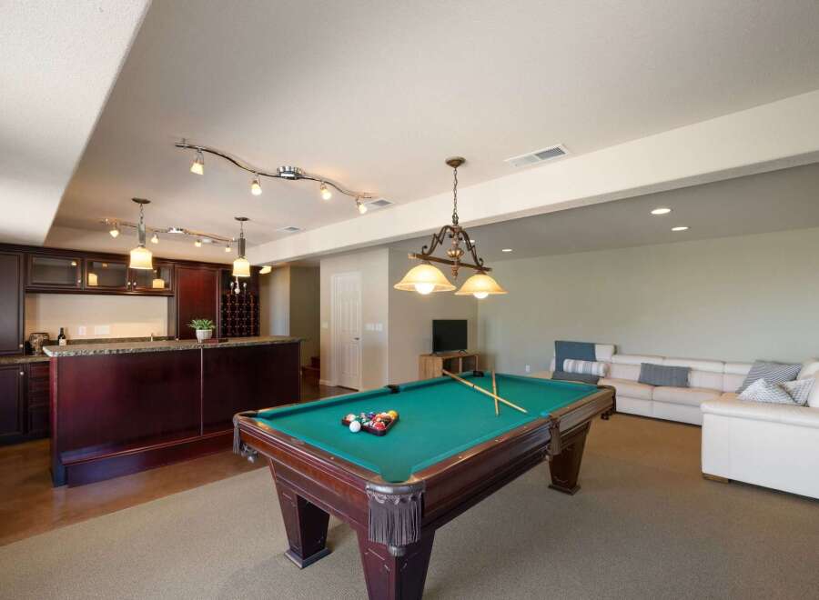 Experience ultimate entertainment in this finished basement featuring a full-service bar and a professional-grade pool table.